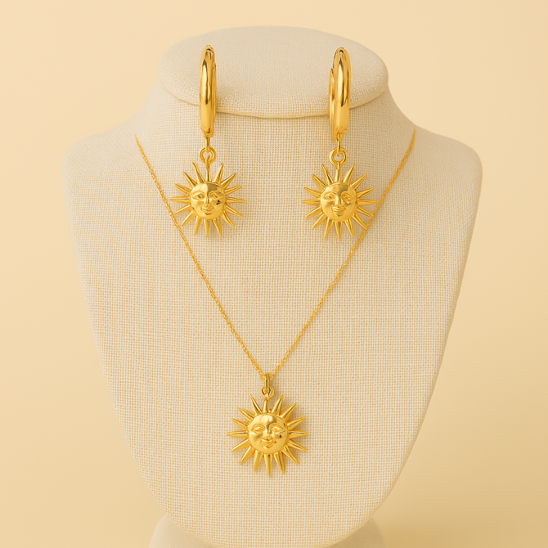 Gold sun motif drop earrings and matching sun pendant necklace on beige display bust, Radiant Duo set by NueJewelz.