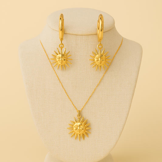Gold sun motif drop earrings and matching sun pendant necklace on beige display bust, Radiant Duo set by NueJewelz.