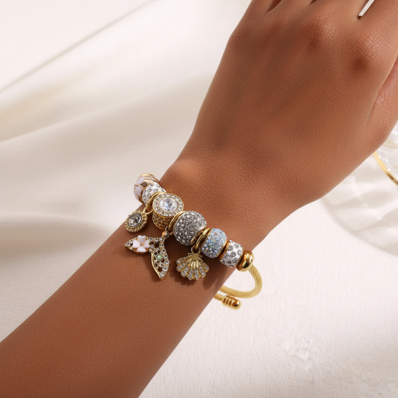 Gold and silver beaded bracelet on a wrist against a white background