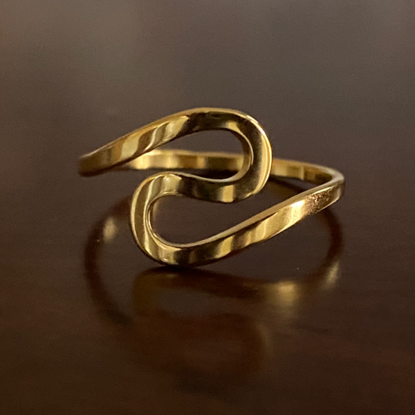 Luxurious gold infinity twist ring with radiant finish on slender band.