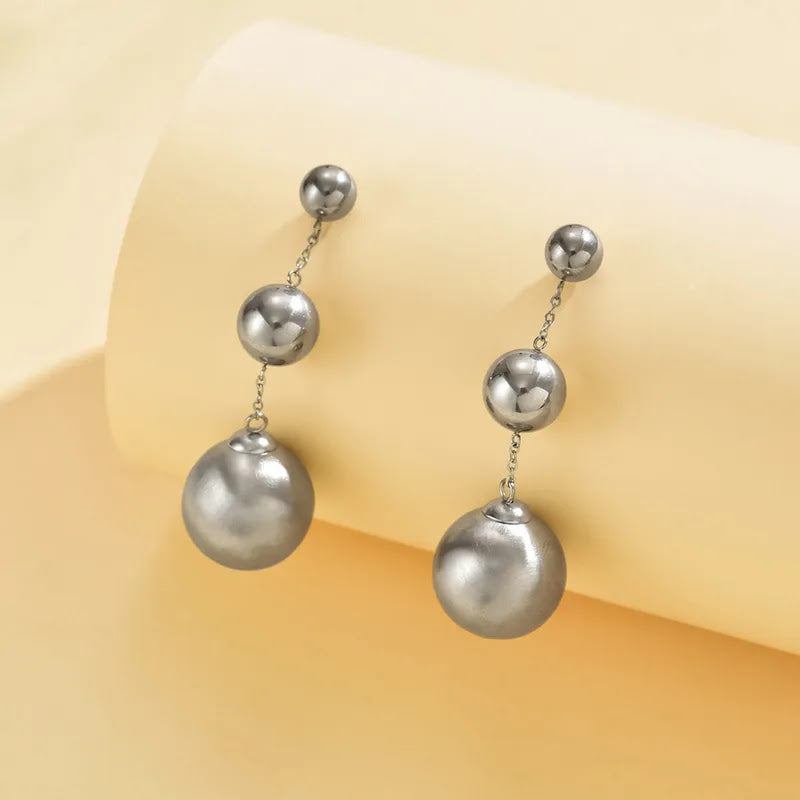 Elegant round stainless steel bead drop earrings on display.