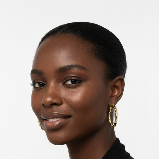 Close-up of a woman wearing gold-tone twisted spiral hoop earrings, Twisted Elegance Hoops, lightweight and stylish accessory