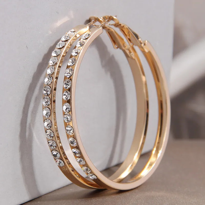 Gold hoop earrings with crystal accents on a light background