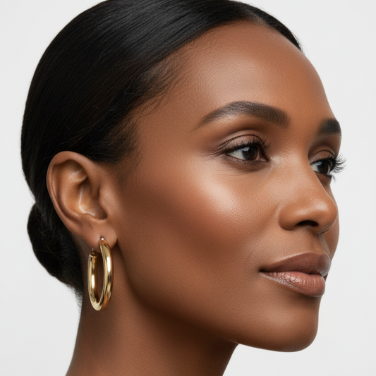 Close-up of a woman wearing The Everyday Hoop chunky stainless steel open hoop earrings.