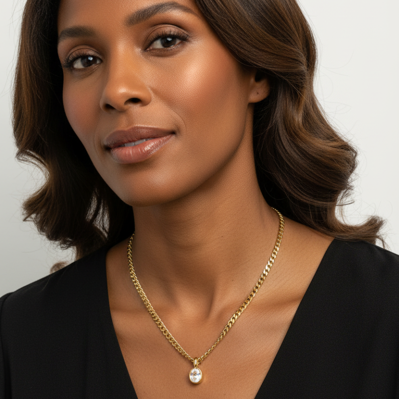 Close-up of woman wearing Oval Stainless Steel gold-tone pendant necklace with faceted oval gemstone and curb chain
