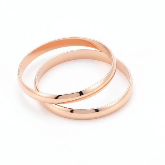 Set of two polished rose gold plated stainless steel bold statement bangles with smooth finish and modern design